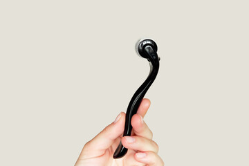 Microneedling roller for skin rejuvenation and beauty treatment in woman's hand