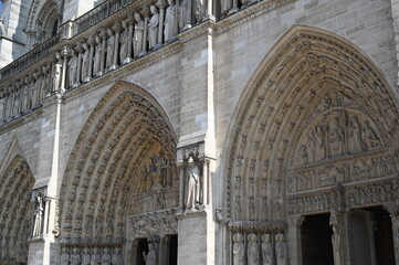 Gothic stone façade with an ornate arched portal, carved sculptures, and detailed architectural...