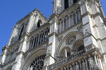 Obraz premium Notre-Dame Cathedral in Paris, France, with clear blue sky. Iconic Gothic architecture and historical landmark symbolizing culture, faith, and European heritage.