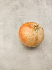 Single onion lying on gray marble countertop copy space preparing vegetables for making soup