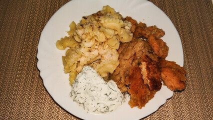 Pasta, breaded chicken breast and yogurt dill sauce creating delicious meal dinner
