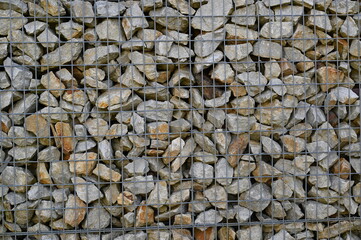 Close-up of a stone and iron mesh retaining wall, artificial retaining wall for crumbling hills 