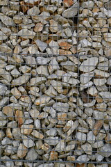 Close-up of a stone and iron mesh retaining wall, artificial retaining wall for crumbling hills 