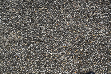 Natural gravel stone texture background with small pebbles and gray rocks. Close-up of rough surface used for construction, landscaping, or design materials.