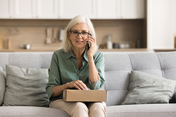Managing online shopping. Happy elderly lady satisfied ecommerce store client call customer support to express gratitude after receiving delivery discuss loyalty discount program in phone conversation