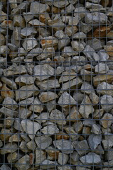 Close-up of a stone and iron mesh retaining wall, artificial retaining wall for crumbling hills 