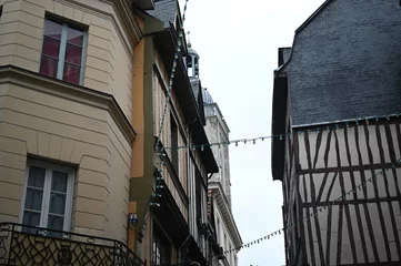Fotobehang Smalle Straten Historic European city architecture with narrow streets and tall buildings under cloudy sky. Old town view — concept of travel, culture, urban lifestyle, and architectural heritage.  © Анна Климчук