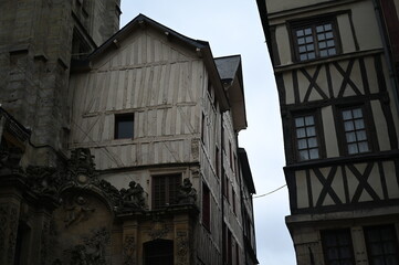 Historic European city architecture with narrow streets and tall buildings under cloudy sky. Old town view — concept of travel, culture, urban lifestyle, and architectural heritage.