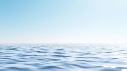 Obraz premium The image shows a calm ocean under a clear sky. The water is a light blue, with gentle waves. The sky is a pale blue, almost white near the horizon. The scene is minimalist, with no other elements pr