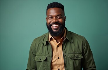 Portrait of smiling African American man in green jacket. Happy male in stylish outfit, brown shirt. Black guy portrait looks at camera. Professional, successful, confident, attractive.