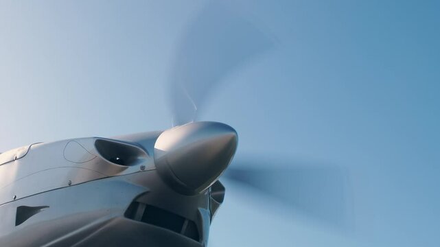 Starting the engine of a propeller single-engine light aircraft. Blades starts to rotate.