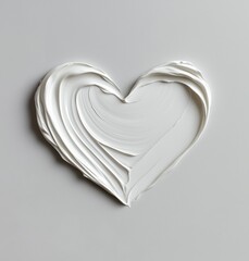 Creative heart shape made of white cream against a soft gray background, showcasing artistic expression and design in a minimalist style