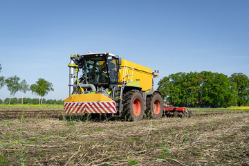 Ein Gülle Selbstfahrer Fahrzeug bei Gülleausbringung und direkter  Einarbeitung in den Boden im Einsatz.