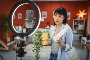 Japanese woman use mobile phone for live stream about home plants