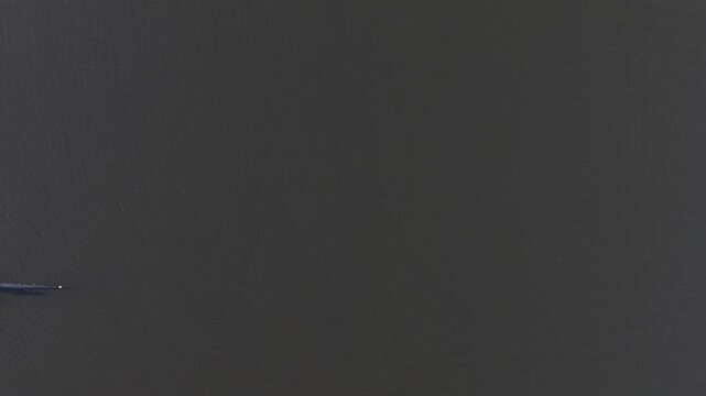 A single scull rowing followed by a 4 man crew rowing in slow motion