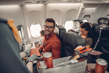 Passengers on a flight can enjoy a variety of snacks and drinks in a comfortable modern airplane interior