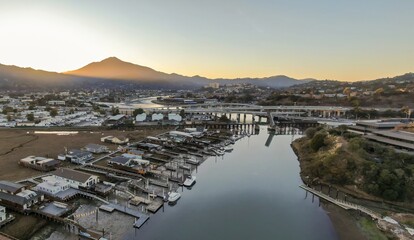 Aerial view of Corte madera Creek in Larkspur, Greenbrae, California, USA, at sunrise. Houses line the riverbank with docks and boats with Mount Tamalpais in the background. © Zenstratus