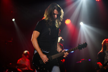 Obraz premium Guitarist performing live on stage with bandmates