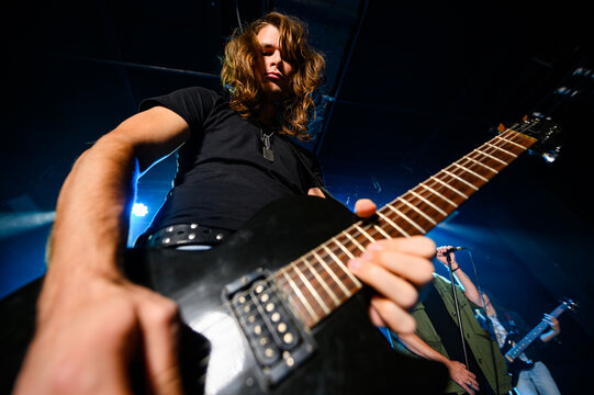 Guitarist performing live music on stage with band