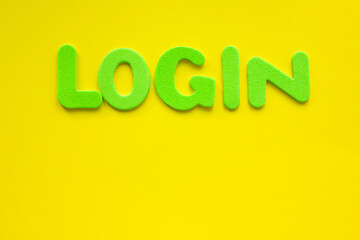 The word LOGIN made with green letters written on a yellow background with copy space.