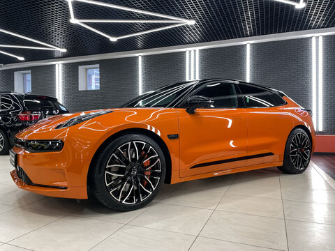 Orange Zeekr 001 modern Electric car in showroom. Exterior of Zeekr 001 Grand Tour coupe. Zeekr is a Chinese electric car brand by Geely. Brand's showroom.Chinese State Car Manufacturers.