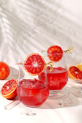 Flyer with glasses of alcoholic drinks and tropical fruits. Royal cocktail of blood orange, ice cubes, rum and tequila. Concept of summer party and rest in a restaurant. Menu for a bar or cafe