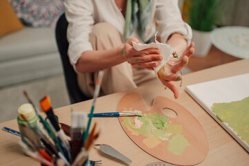 Artist cleaning paint stains from hand after creative work session