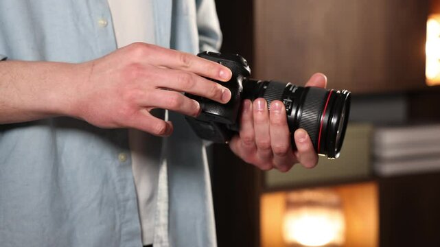 Man inserting SD memory card into photo camera indoors, closeup