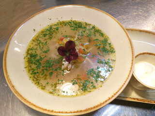 chicken broth or soup with vegetables and quail meat in a round plate, top view. Homemade healthy...