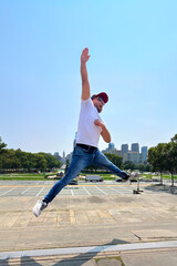 A man in a white shirt and blue jeans is jumping in the air