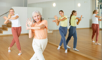 Fototapeta premium Ordinary active females exercising dance moves in dance center