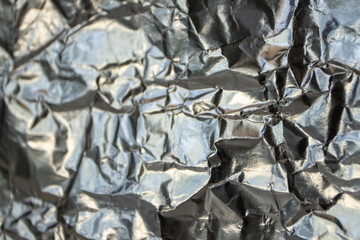 Silvery metallic crumpled foil selective focus background