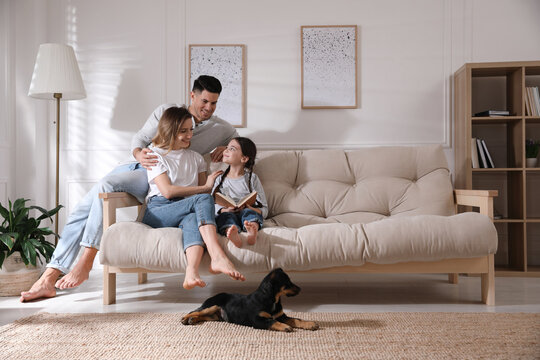 Happy family on sofa and puppy in living room