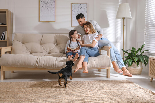 Happy family on sofa and puppy in living room