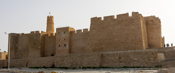 Scenic view of robust stone outer walls with strategic watchtowers of medieval Ribat of Monastir,...