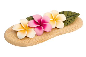 Naklejka premium A Three colorful plumeria flowers, two white and one pink, rest on wooden tray with green leaf, creating serene and tropical ambiance