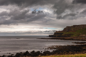 A rocky shoreline with a cloudy sky in the background