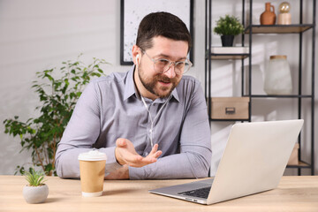 Online speaker streaming with laptop at table indoors