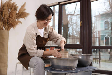 Hobby and craft. Smiling woman making pottery indoors