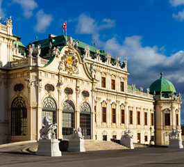 Obraz premium Scenic view of main facade and entrance of baroque building of upper Belvedere palace with large staircase and various sculptures on sunny day, Vienna, Austria