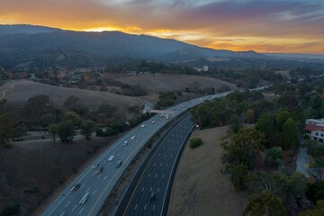 Aerial view of cars traveling on Interstate 280 at dusk in Cupertino, California, USA. Commuters are driving home from work during rush hour.