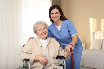 Fototapeta premium Healthcare worker with elderly woman in wheelchair indoors