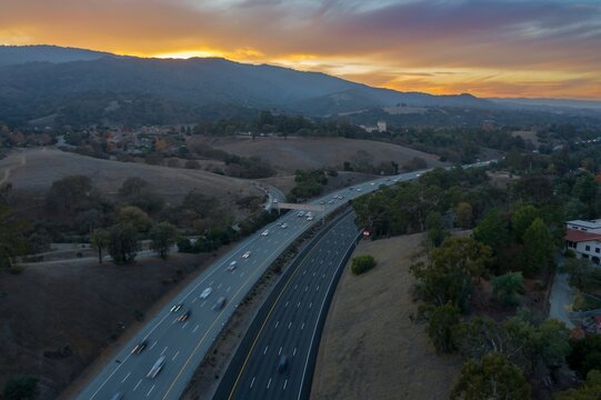 Aerial view of cars traveling on Interstate 280 at dusk in Cupertino, California, USA. Commuters are driving home from work during rush hour.
