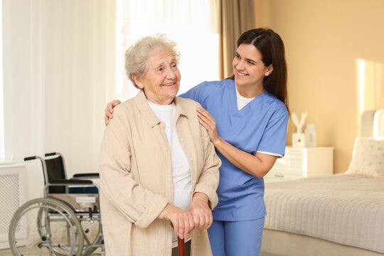 Smiling healthcare worker and elderly woman indoors