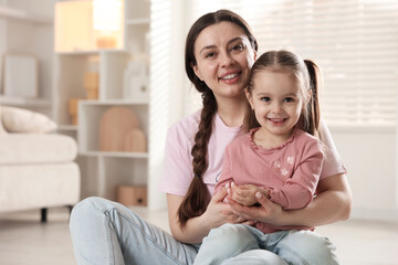Fototapeta premium Family portrait of beautiful mother with little daughter at home. Space for text
