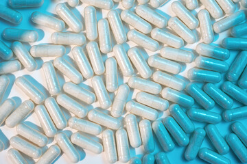 Close up of medical capsules on white background with blue shadows