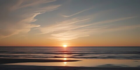 Obraz premium A serene ocean sunset with the sun setting over the horizon, symbolizing peace and nature, ideal for landscape and travel themes.