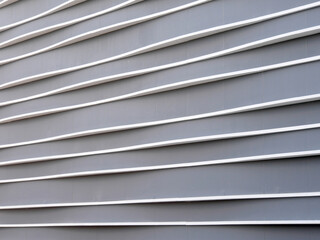 Obraz premium Modern building facade with horizontal grey and white lines, Background