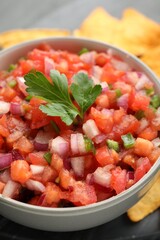 Delicious salsa in bowl on table, closeup