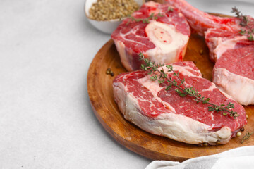 Pieces of raw beef and spices on light grey table, closeup. Space for text